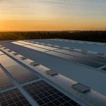 Illustrative photo: rooftop solar panels at sunset