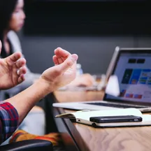 Illustrative photo: a workplace discussion beside a laptop